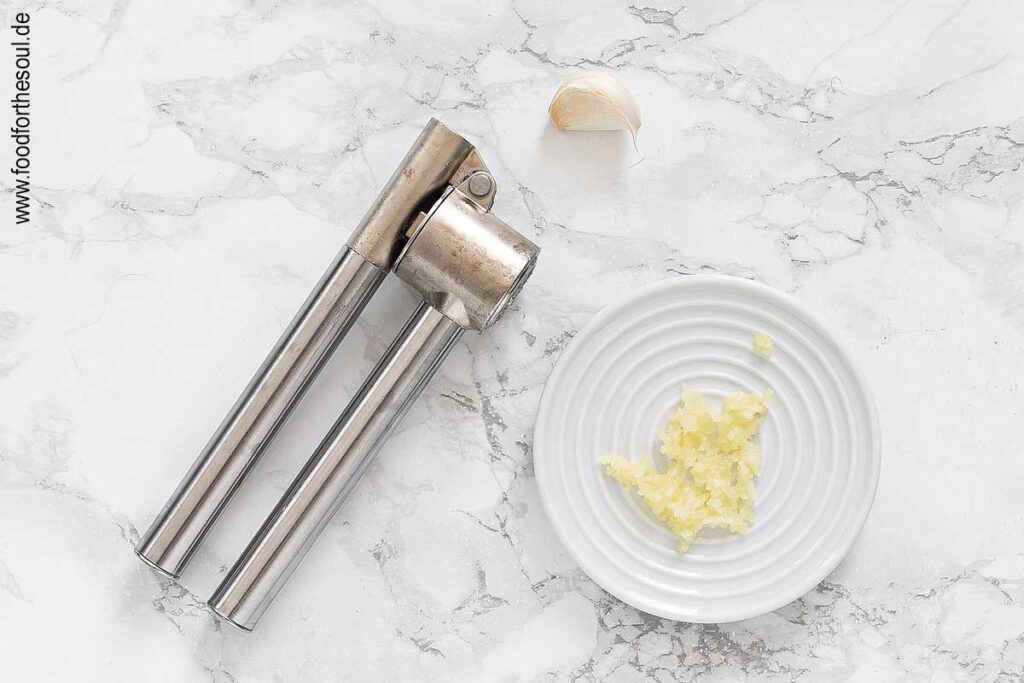 Knoblauch schälen und durch Knoblauchpresse drücken - Schritt 1