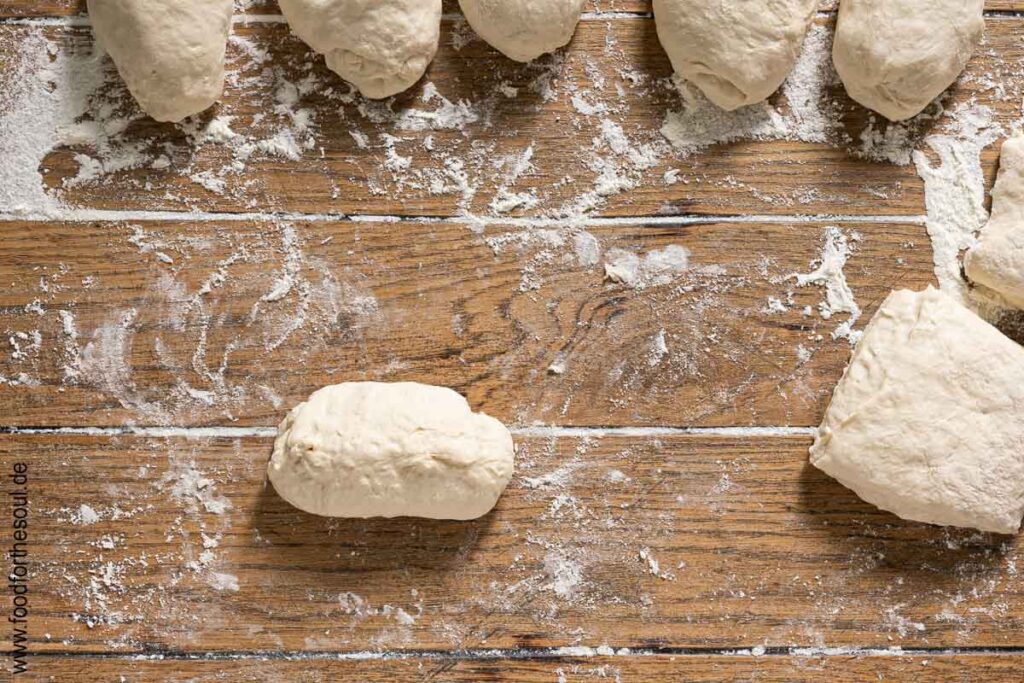 Ende des Hefeteigstücks fest wie eine Naht zusammendrücken und Brötchen formen - Schritt 10